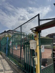 Exterior yard area of ILG School, enclosed by tall metal gates
