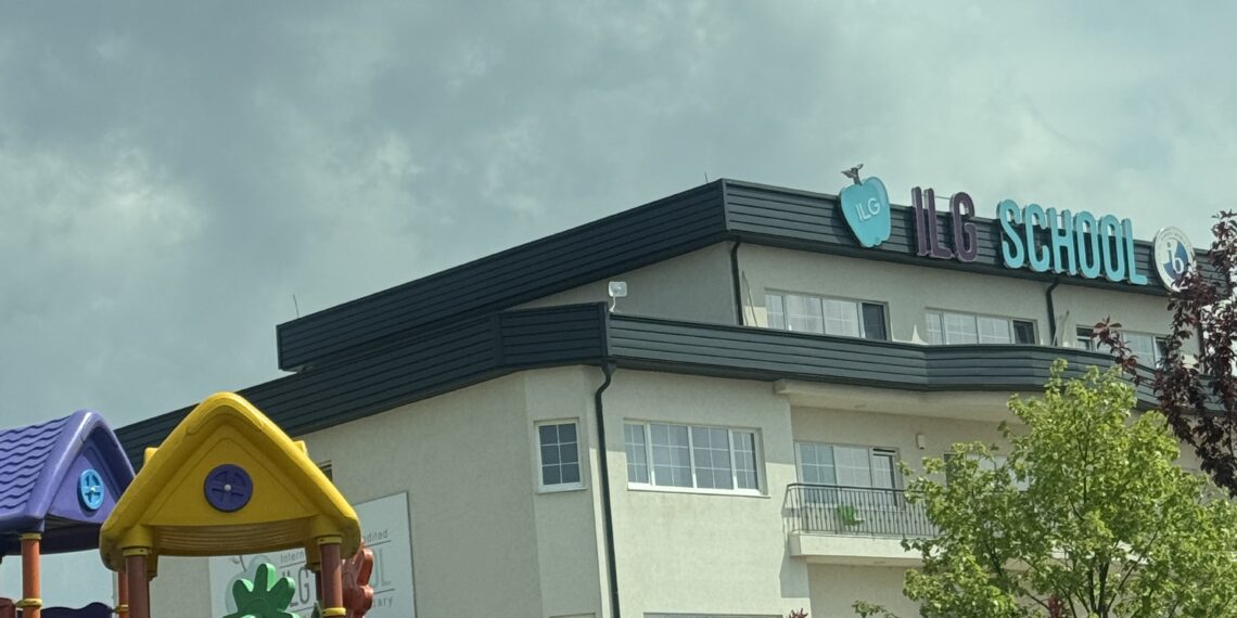 Front view of ILG School in Pristina, Kosovo, displaying the school's name and IB accreditation logo on the exterior wall.