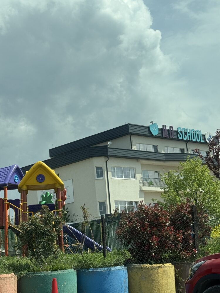Front view of ILG School in Pristina, Kosovo, displaying the school's name and IB accreditation logo on the exterior wall.